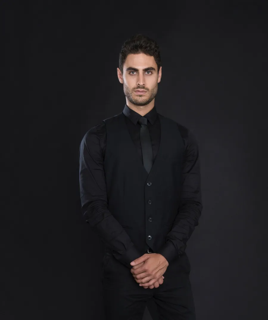 Server in all black uniform: black button-up shirt, black tie, and black pants