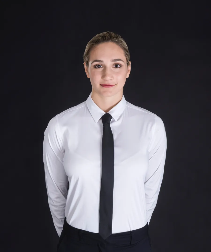 Server in black and white uniform: white button-up shirt, black tie, and black pants